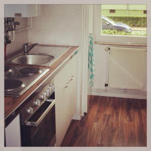a kitchen with a sink and a stove and a window at Ferienwohnung Ana in Hannover
