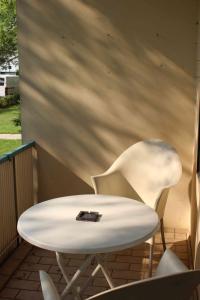 una mesa blanca y 2 sillas en un porche en Ferienwohnung Ana, en Hannover