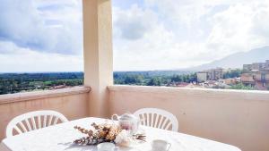 維拉普特祖的住宿－S'Arrosa de Monti，一张带白色椅子的桌子,享有城市美景