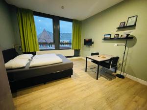 a bedroom with a bed and a desk and a window at Short Stay Wageningen in Wageningen