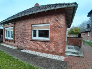 Una casa de ladrillo con una ventana en el costado. en Ferienhaus am alten Postamt, en Hanerau-Hademarschen