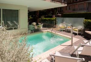 una pequeña piscina con sillas y avisor en Atlas Hotel, en Riccione