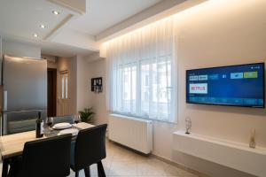 a dining room with a table and a tv on the wall at Diamond Palace Trikala in Tríkala