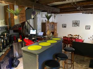 un bar in un ristorante con tavoli e sgabelli gialli di Chez Tifille a Estaing