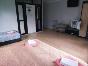 Nizhnaya KhobzaにあるGuest house Nadiezhdaのベッド1台とタオル2枚が備わる客室です。