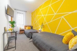 a bedroom with two beds and a yellow wall at Penzion Expo Dream #33 by Goodnite cz in Brno