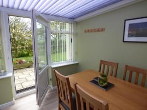 a dining room with a table and a window at Hafod Cottage in Cemaes Bay
