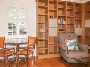 a dining room with wooden shelves and a table and chairs at 1 Old Talbot Cottages in Lostwithiel