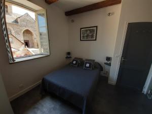 a small bedroom with a bed and a window at Chez Tifille in Estaing