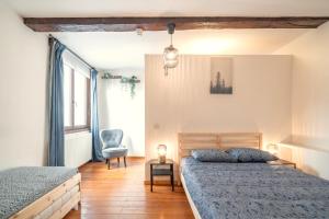 a bedroom with two beds and a chair in it at The Old Town Lodge in the Heart of Antwerp in Antwerp