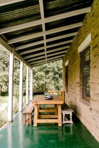 Henburg Park的住宿－Crompton Cottage，天井上的木桌和长凳