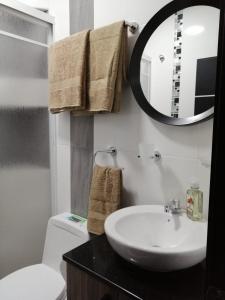 bagno con lavandino, specchio e servizi igienici di UMBRELLA SUITE a Manta