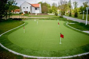 um campo de golfe verde com bandeiras vermelhas em Batthyány Kúria em Zalacsány