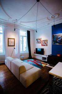ein Wohnzimmer mit einem Sofa und einem TV in der Unterkunft GITADIN - Deluxe Suite Valens - Historical Center in Lüttich