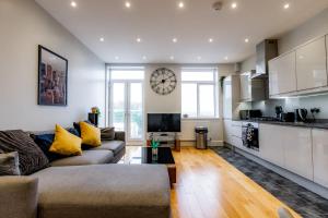 a living room with a couch and a clock on the wall at Thorpe Road 1 Bed Apartment with Parking in Norwich