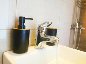 a bathroom sink with a faucet and two cups at 7-Athens new morden comfortable-center,metro,private parking in Athens +19 photos