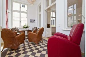 ein Wohnzimmer mit roten Stühlen und einem karierten Boden in der Unterkunft Die Villa, App 1 in Ahlbeck