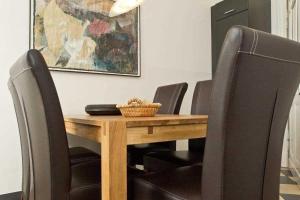 einen Esstisch mit schwarzen Stühlen um ihn herum in der Unterkunft Die Villa, App 1 in Ahlbeck