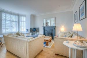 a living room with two couches and a table at Preswylfa in Abersoch