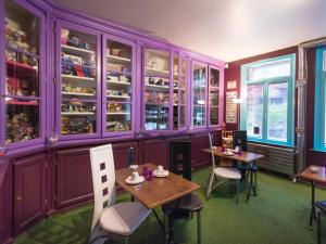 a dining room with purple cabinets and tables and chairs at Suivez Le Lapin Blanc-BB Chambres d'Hôtes in Saint-Valery-sur-Somme