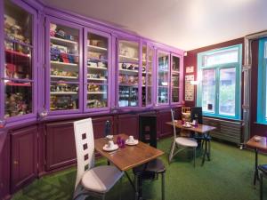 a dining room with purple cabinets and tables and chairs at Suivez Le Lapin Blanc-BB Chambres d'Hôtes in Saint-Valéry-sur-Somme