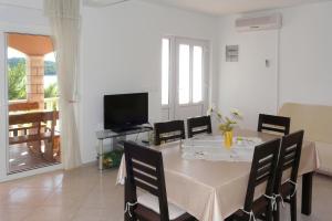 een eetkamer met een tafel met stoelen en een televisie bij Apartment in Prizba with sea view, balcony, air conditioning, WiFi 5080-1 in Korčula