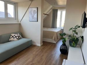 a living room with a couch and a bed at Weltevreden in Noordwijk
