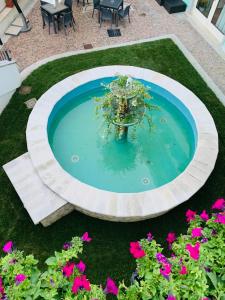 une petite fontaine au milieu d'une pelouse fleurie dans l'établissement Hotel San Berardo, à Pescina