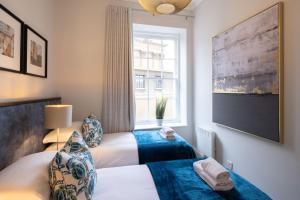 two beds in a hotel room with a window at Redmayne House - Urban Apartments in Bristol
