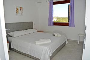 1 dormitorio con 1 cama con 2 toallas en Residence Eolo, en Porto Pozzo