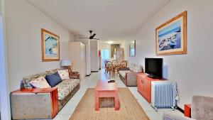 sala de estar con sofá y TV en Summerhill Self-Catering Holiday Accommodation, en Plettenberg Bay