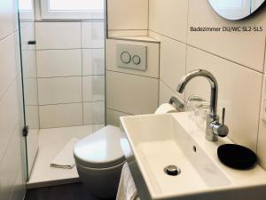un baño con lavabo e inodoro en Haus Strandleben, en Norderney 11 fotos más