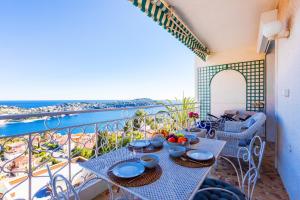 a table on a balcony with a view of the ocean at Terrace on the Bay 2 Villefranche-sur-Mer, AP4243 by Riviera Holiday Homes in Villefranche-sur-Mer