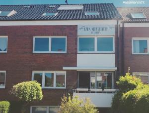 un edificio de ladrillo rojo con un cartel que lee la farmacia Tucks Mountain en Haus Strandleben, en Norderney