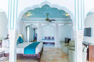 een slaapkamer met een kingsize bed en een bank bij Royal Heritage Haveli in Jaipur