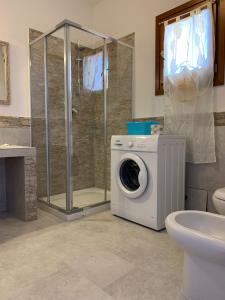 uma casa de banho com uma máquina de lavar roupa e um chuveiro em Residence Eolo em Porto Pozzo