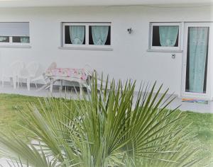 ein weißes Haus mit einem Tisch und Stühlen im Hof in der Unterkunft Casa Landoni in Mendrisio