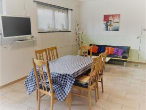 a dining room with a table and chairs and a tv at Casa Landoni in Mendrisio