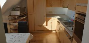 eine Küche mit Holzschränken, einer Spüle und einer Mikrowelle in der Unterkunft Oktopus in Hannover