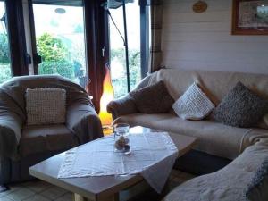 a living room with couches and a coffee table at Holiday home on Lake Henne with terrace in Meschede