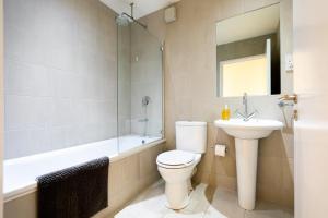 a bathroom with a toilet and a sink and a bath tub at Modern and Spacious 1 Bed Apartment City Centre in Norwich