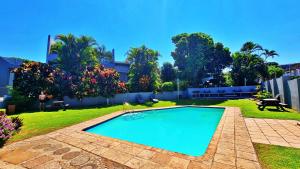 a swimming pool in a yard with grass and trees at Ocean Villa in Durban +44 photos