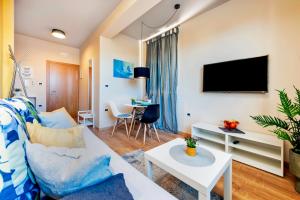 uma sala de estar com um sofá e uma televisão em Room and Apartments Antea em Rovinj