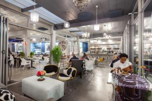 Un restaurante con mesas y gente sentada en las mesas. en Chill Pepper Boutique Hotel, en Nelspruit