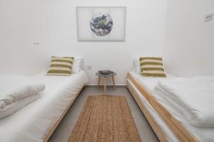 2 camas blancas en una habitación con mesa en Achziv Sea&Sun, en Nahariyya