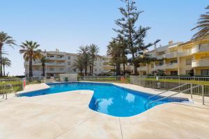 a swimming pool in front of a apartment building at Beach apartment La Cala in La Cala de Mijas