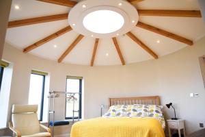 a bedroom with a yellow bed and a vaulted ceiling at Isle of Skye Rotunda in Ollach