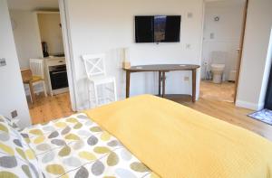 um quarto com uma cama, uma mesa e uma televisão em Isle of Skye Rotunda em Ollach