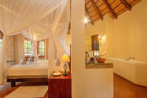 um quarto com uma cama e uma banheira e um quarto com uma banheira em Casart Game Lodge em Grietjie Game Reserve