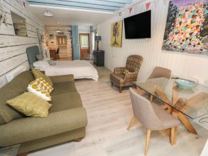 a living room with a couch and a table at The Studio in Tenby
